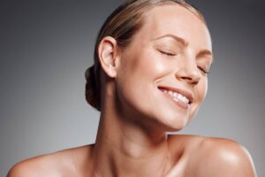 Smiling woman with radiant skin and smooth facial contours symbolizing successful facelift preparation and results.